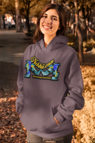 Earth Bound Women Hoodies - Shop Now for Style & Comfort featuring a smiling woman wearing a purple hoodie with colorful graphic text in a fall park setting.