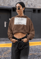 Brown cropped eco hoodie for women with bold front print, blending sustainable comfort and minimalist streetwear style.