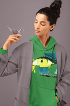 Green cropped women's hoodie with artistic eye print and empowering vibe, worn under a gray coat. Eco-conscious fashion for active lifestyles.