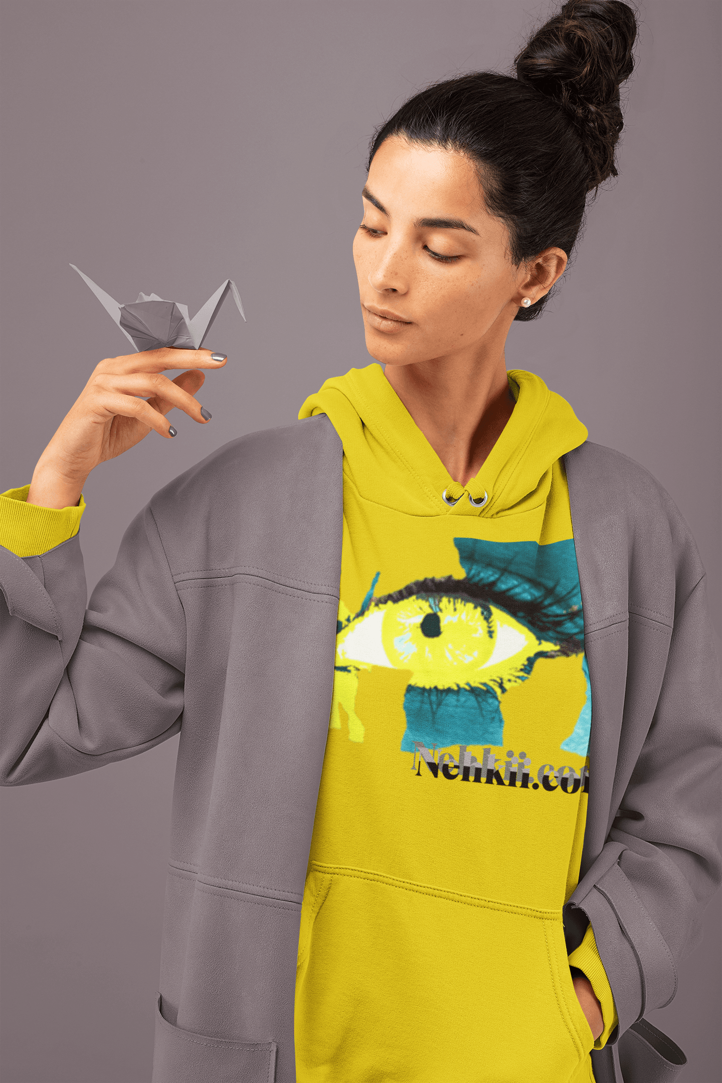 Yellow cropped women's hoodie with striking eye artwork and empowerment message, paired with a gray jacket. Lightweight and sustainable hoodie.